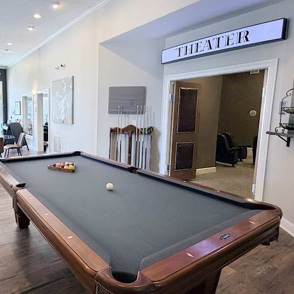 a pool table in a room with a sign that says "theater".