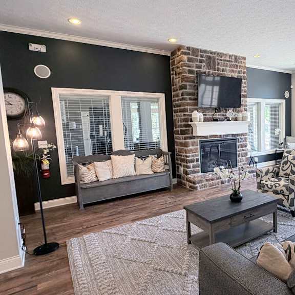 a living room with a grey couch, a fireplace, and a television.