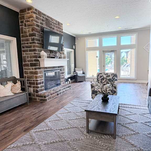 a living room with a fireplace and a grey couch.