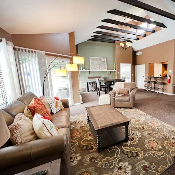 a living room with brown leather furniture and a patterned rug.