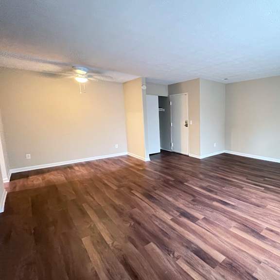 a room with wooden flooring and a door in the background.