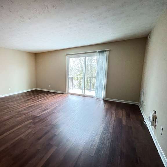 a room with wooden flooring and a sliding glass door.