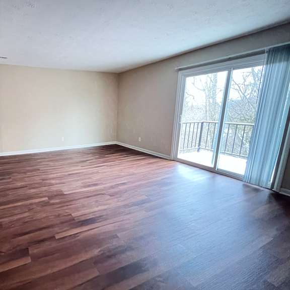 a room with wooden flooring and a sliding glass door.
