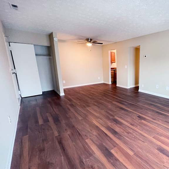 a room with wooden flooring and a ceiling fan.
