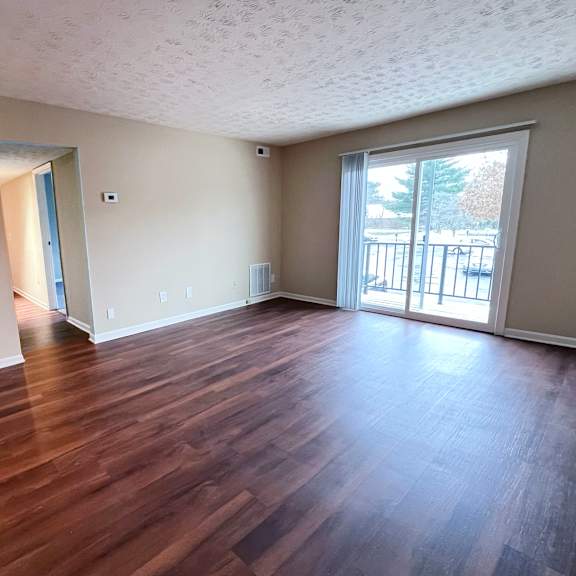 a room with wooden flooring and a sliding glass door.