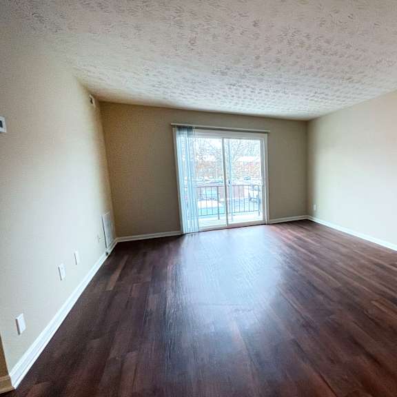 a room with wooden floors and a sliding glass door.