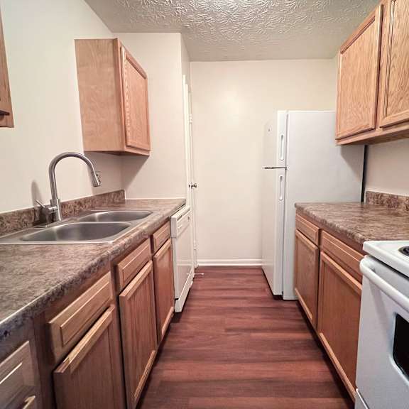 a kitchen with wooden cabinets and a white oven.