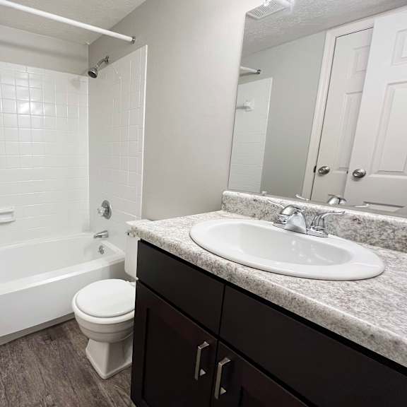 an empty bathroom with a sink toilet and bath tub at crown crossing apartments, amelia, oh, 45102