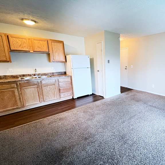 a kitchen with wooden cabinets and a white refrigerator at crown crossing apartments, amelia, 45102