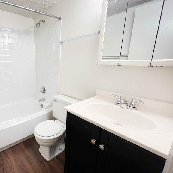 a white bathroom with a toilet, sink, and bathtub at crown crossing apartments, amelia, ohio