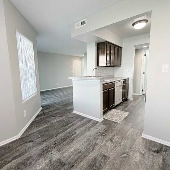 a kitchen area with a white countertop and wooden cabinets.
