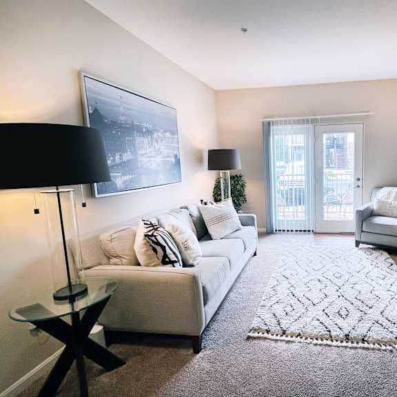a living room with a white couch and a black floor lamp.
