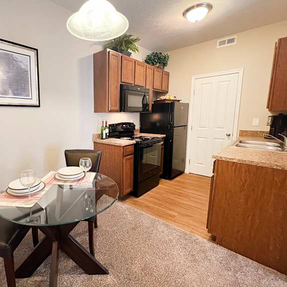 an open kitchen and dining area with a glass table at the residences at liberty crossing, columbus, 43235