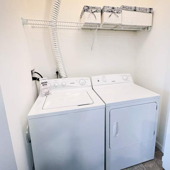 a white washing machine and dryer in a small laundry room.