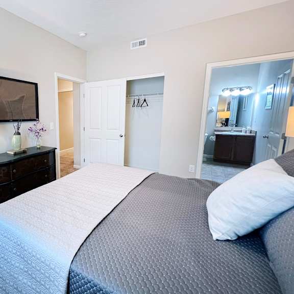 a bedroom with a large bed and a dresser with a mirror above it.