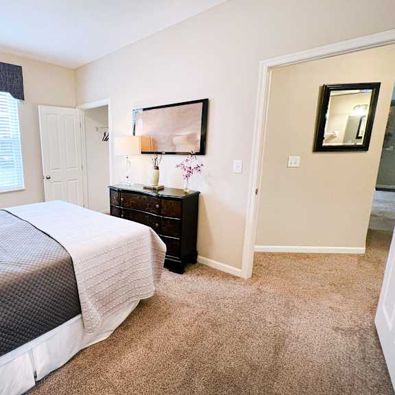 a bedroom with a bed, nightstand, and lamp.