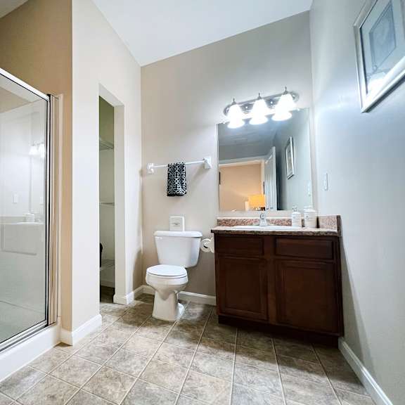 a bathroom with a toilet, sink, and mirror.