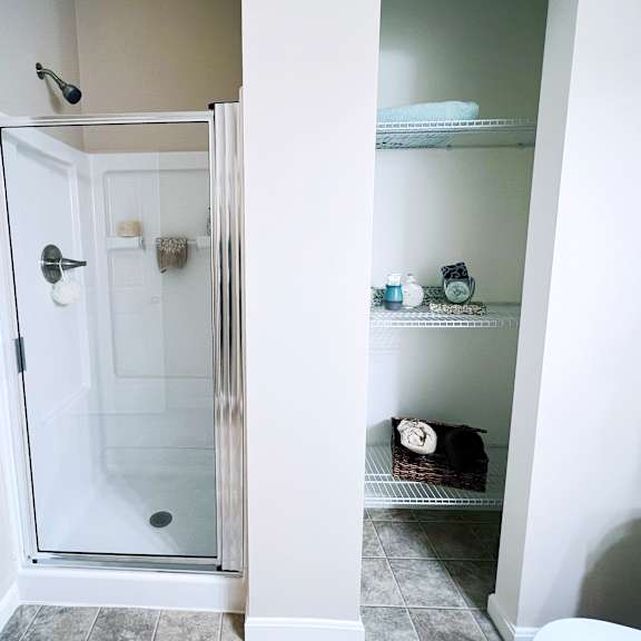 a bathroom with a walk in shower and a towel rack.