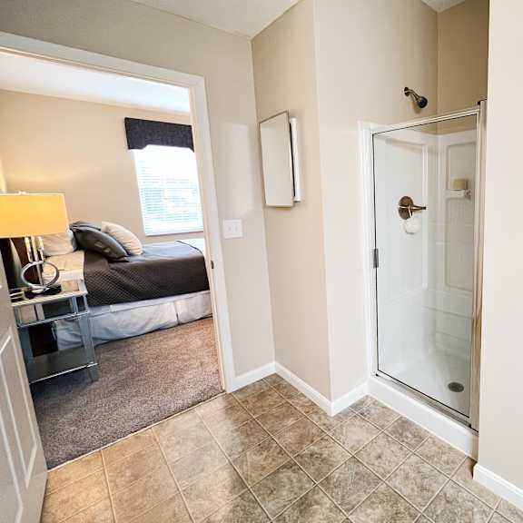 a bathroom with a shower and a bedroom with a bed at the residences at liberty crossing, columbus