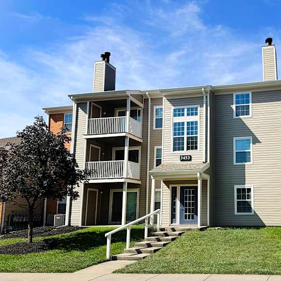 a two-story apartment building with a balcony on the second floor.