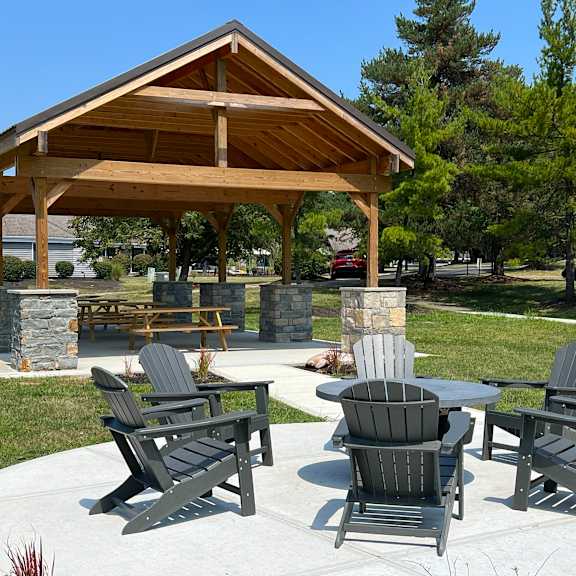 a patio with tables and chairs in front of a pavilion at deercross apartments, ohio, 45236