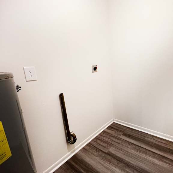 an empty room with a white wall and wooden floors at four worlds apartments, cincinnati, oh