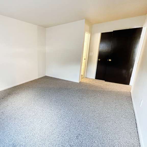 an empty room with white walls and a carpet floor at four worlds apartments, cincinnati, 45231