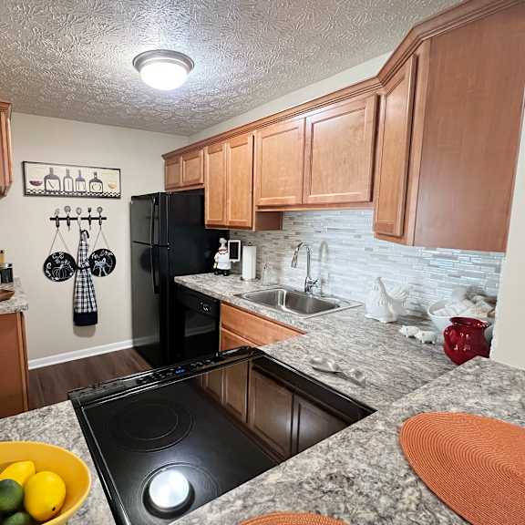 full kitchen with black appliances and granite countertops  at fox run apartments, cincinnati, oh, 45236