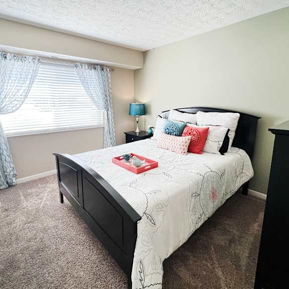 an empty bedroom with a bed and a window  at fox run apartments, cincinnati, oh, 45236
