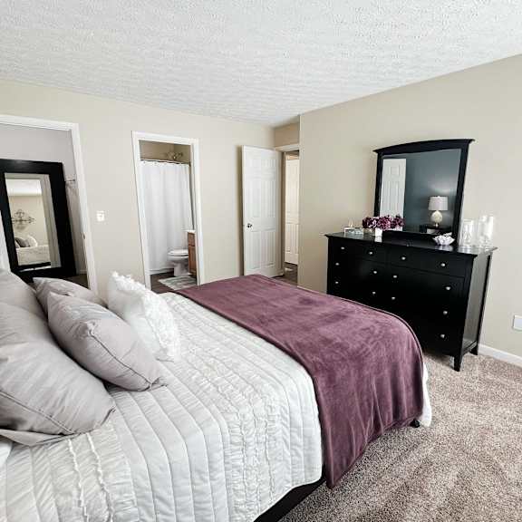 a bedroom with a bed and a dresser and a mirror at fox run apartments, cincinnati