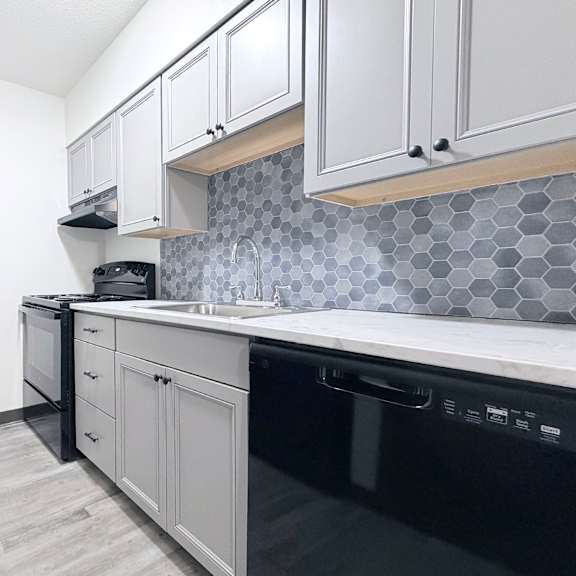 a kitchen with black appliances and white cabinets.