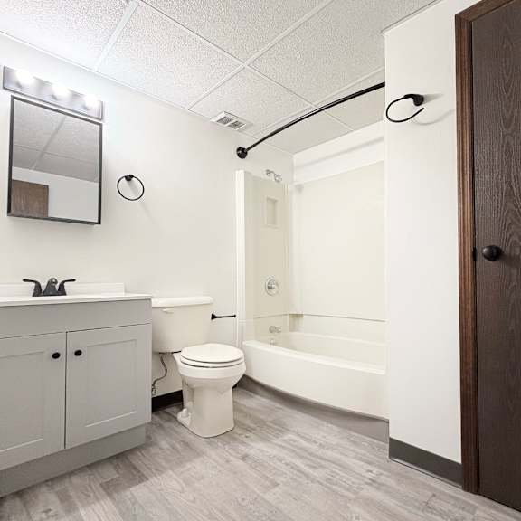 a white toilet sits in a bathroom next to a bathtub.