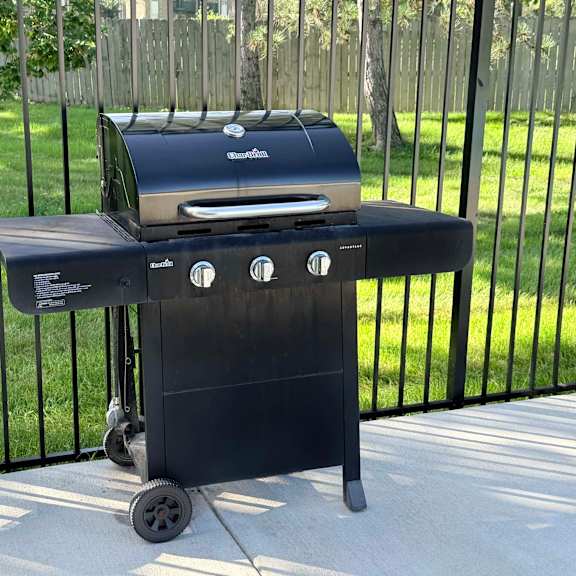 a charcoal grill is on a patio.
