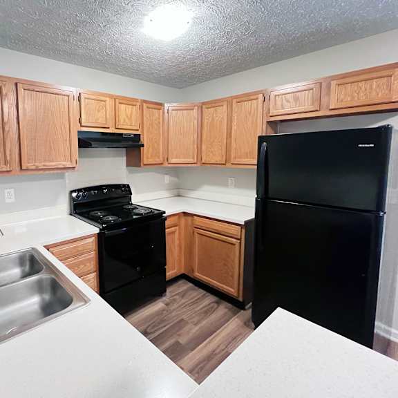 a kitchen with wooden cabinets and black appliances.
