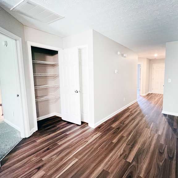 a room with wood flooring and white walls.