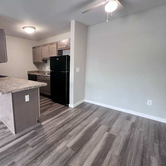 a kitchen area with a black fridge and a countertop.