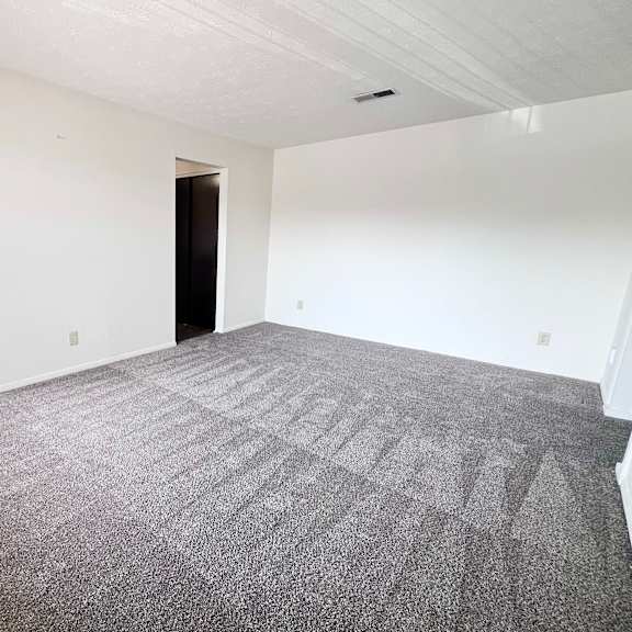 a room with a carpeted floor and white walls.