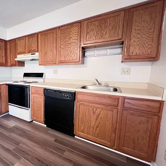 a kitchen with wooden cabinets and a white fridge.
