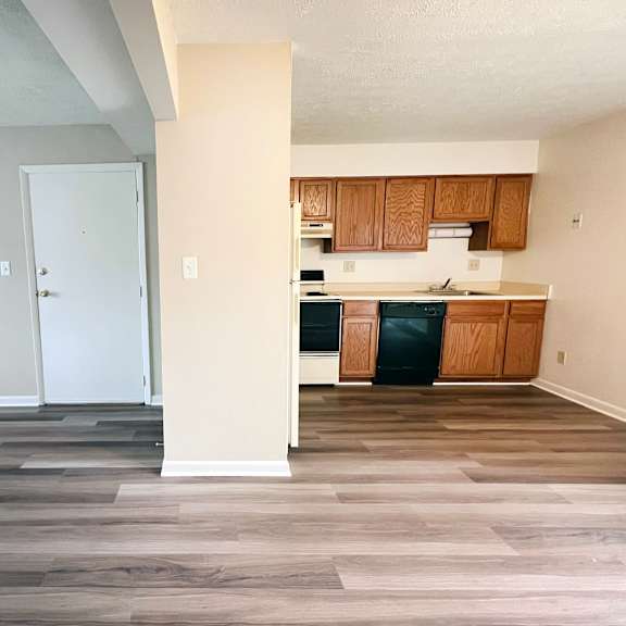 a kitchen with wooden cabinets and a white door.