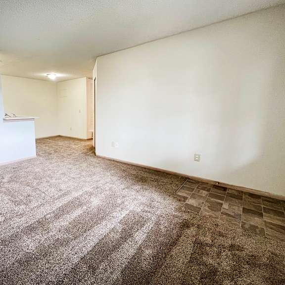 a room with white walls and a multicolored carpet at eagle crest apartments, galloway, oh 43119