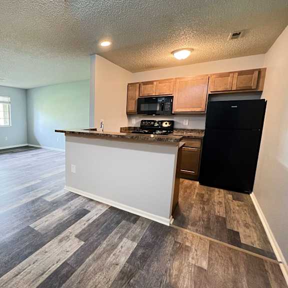 the view of a kitchen and living room in an empty apartment at eagle crest apartments, ohio