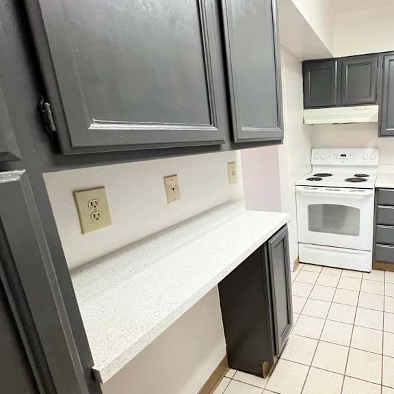 a kitchen with black cabinets and white appliances and a sink at indian lookout apartments, cincinnati