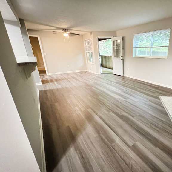 an empty living room with a fireplace and wooden floors at the vinings apartments, cincinnati, ohio