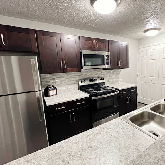 a kitchen with stainless steel appliances and granite counter tops at the vinings apartments, cincinnati, oh, 45245