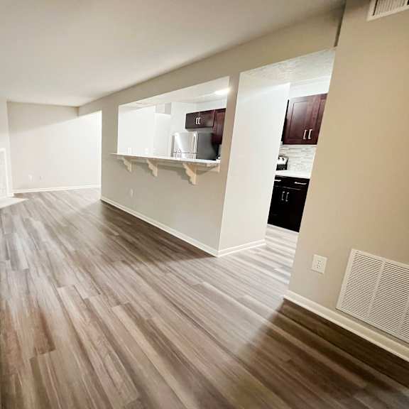 an empty living room with wooden floors and a fireplace at the vinings apartments, cincinnati, 45245