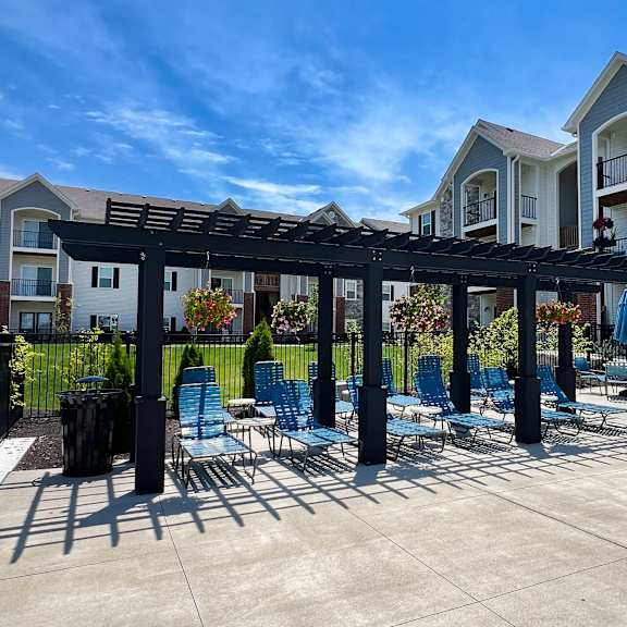 a patio with chairs and a pergola in front of an apartment building at parkway trails, florence, kentucky
