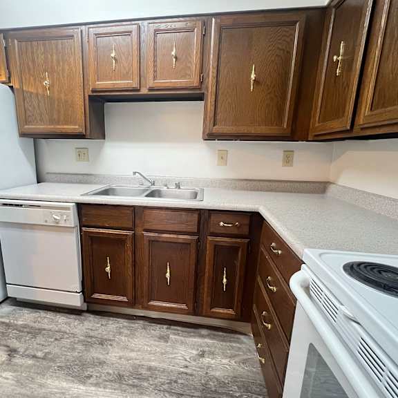 a kitchen with a white refrigerator, white dishwasher, and white stove.