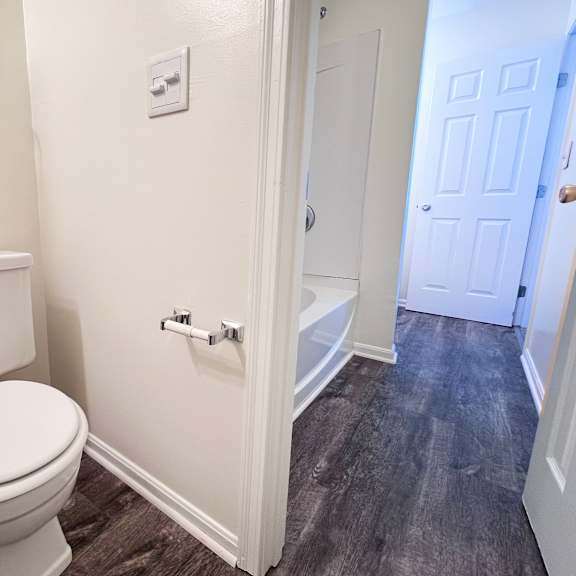 a white toilet in a small bathroom with a white door.