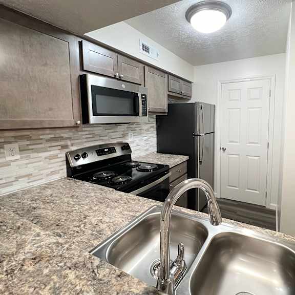 a kitchen with stainless steel appliances and granite counter tops at deercross apartments, ohio