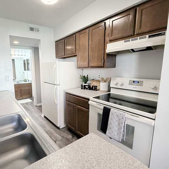 a kitchen with a stainless steel sink and white appliances.